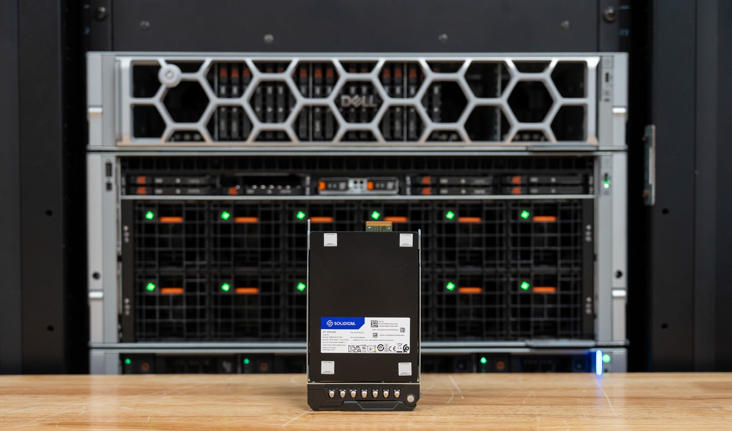 Solidigm D7-PS1030 12.8TB E3.S SSD standing in front of the Dell PowerEdge XE7740 in the StorageReview lab