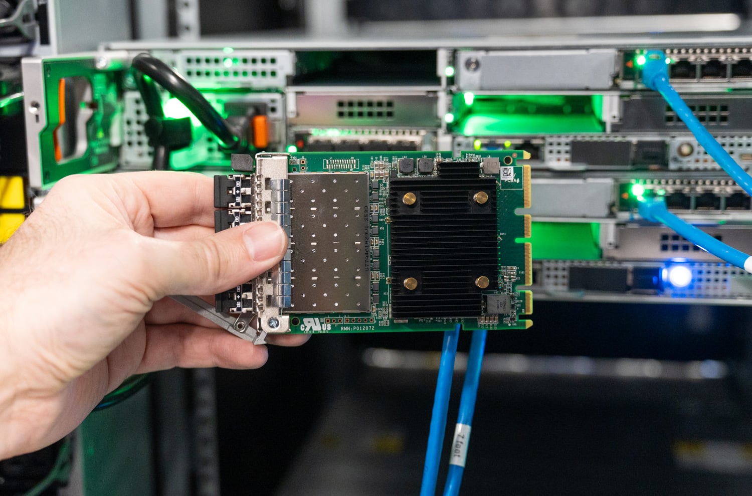 Dell PowerStore Gen 3 quad-port Fibre Channel OCP card held in front of the array rear I/O slots in the StorageReview lab