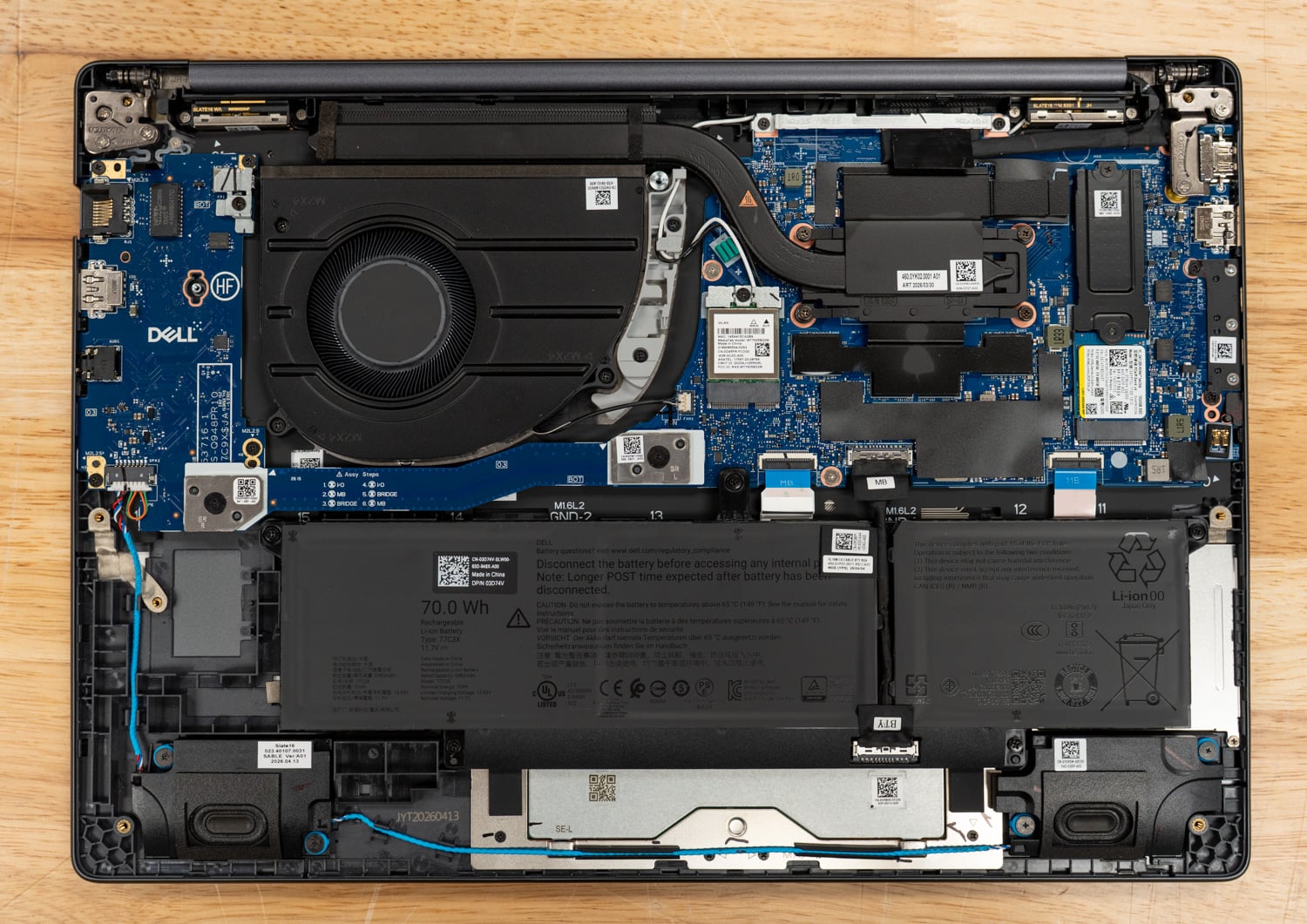 Dell Pro Precision 5 16s AMD internals with the bottom cover removed: fan, heatpipe, battery, and speaker layout