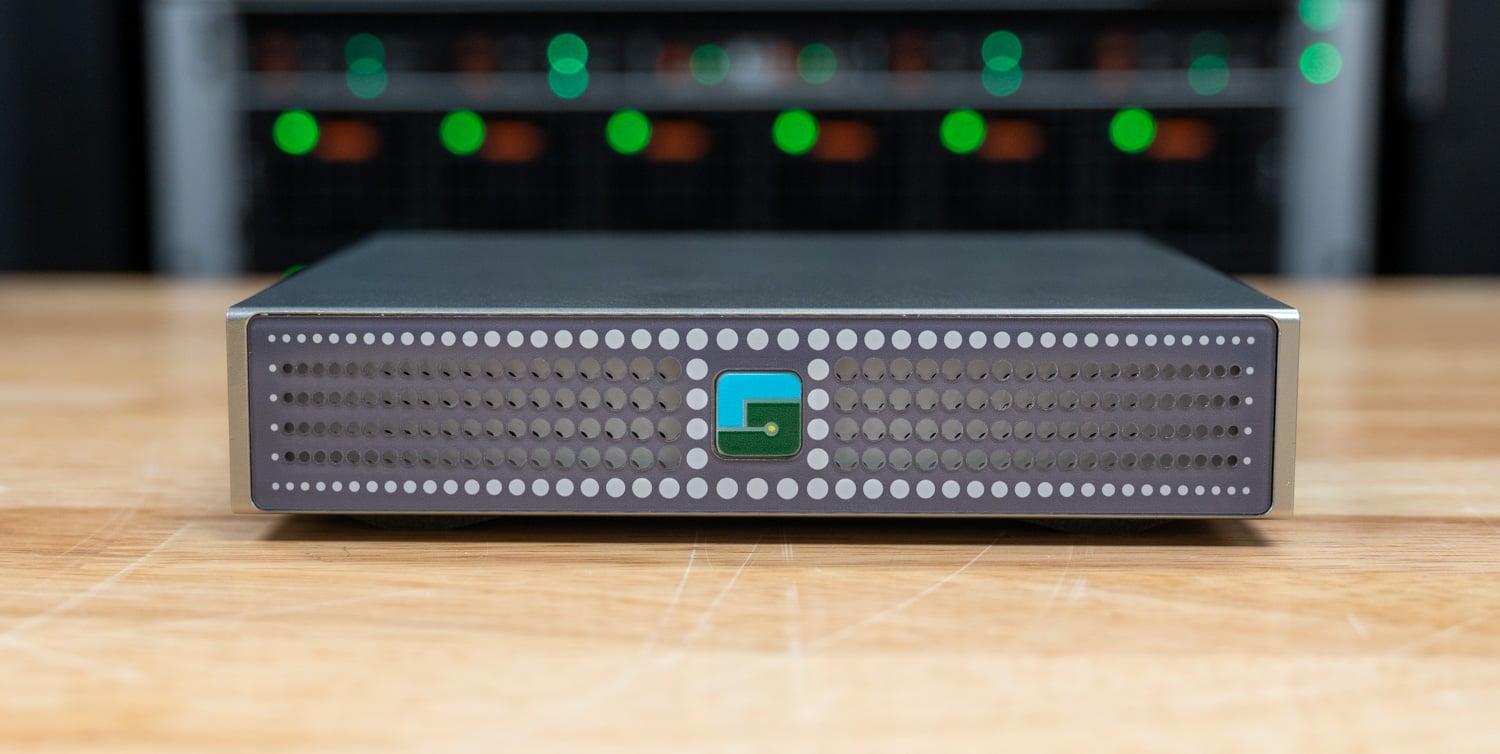 Luisuantech GP Spark front panel with perforated fascia and illuminated logo power button, lab racks behind