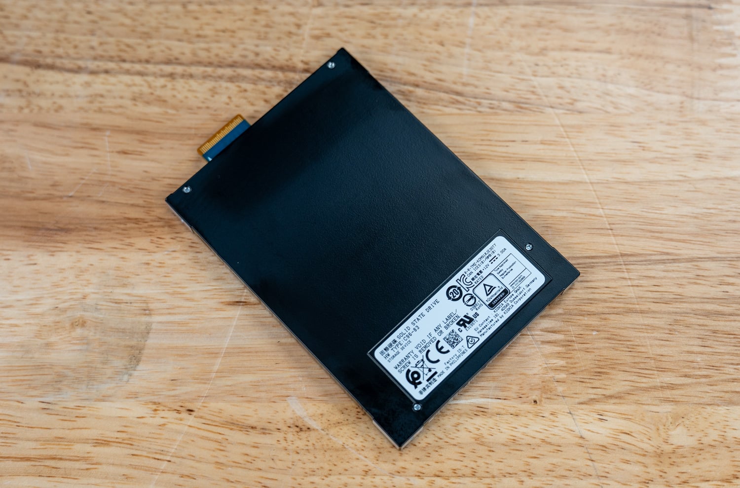 KIOXIA CM9-R E3.S SSD lying flat on the bench, regulatory label side up
