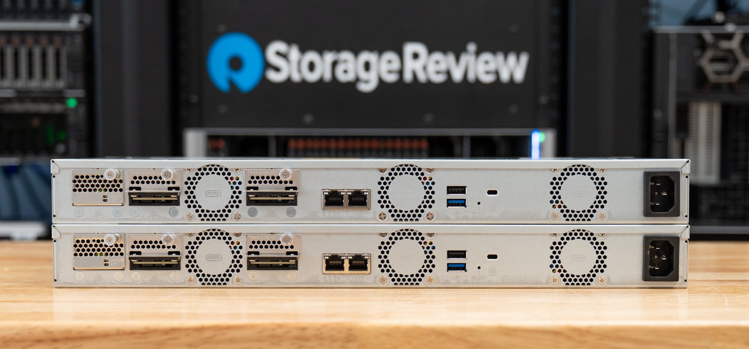 Rear panel of the stacked QNAP TS-h765eU pair showing the E1.S network module bays, 2.5GbE ports, USB, and the single power inlet on each node