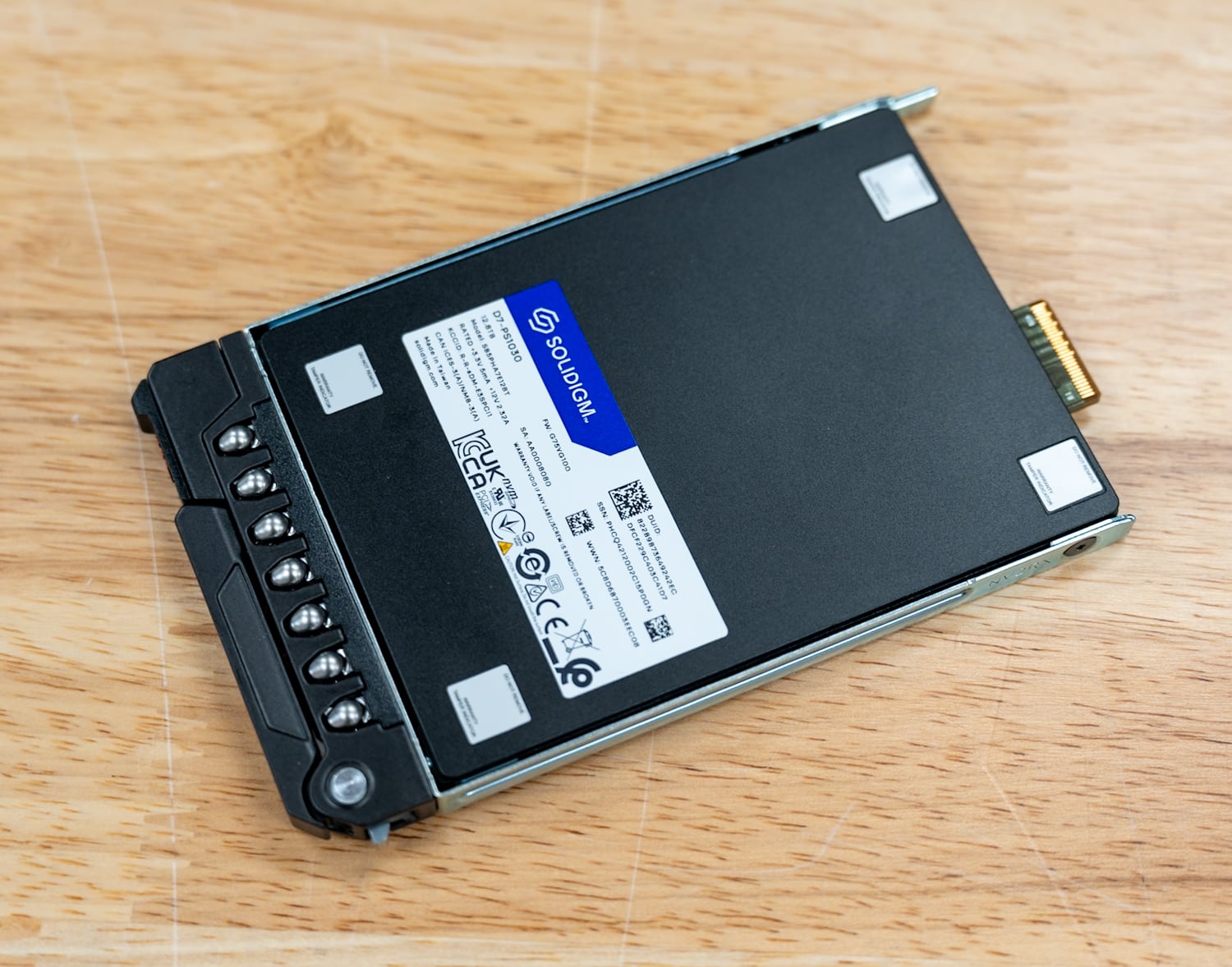 Solidigm D7-PS1030 E3.S drive in its caddy showing the EDSFF edge connector