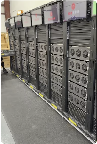 Row of ServerPartDeals StorNado test racks filled with Storinator chassis, with a monitor above each rack showing drive scan status