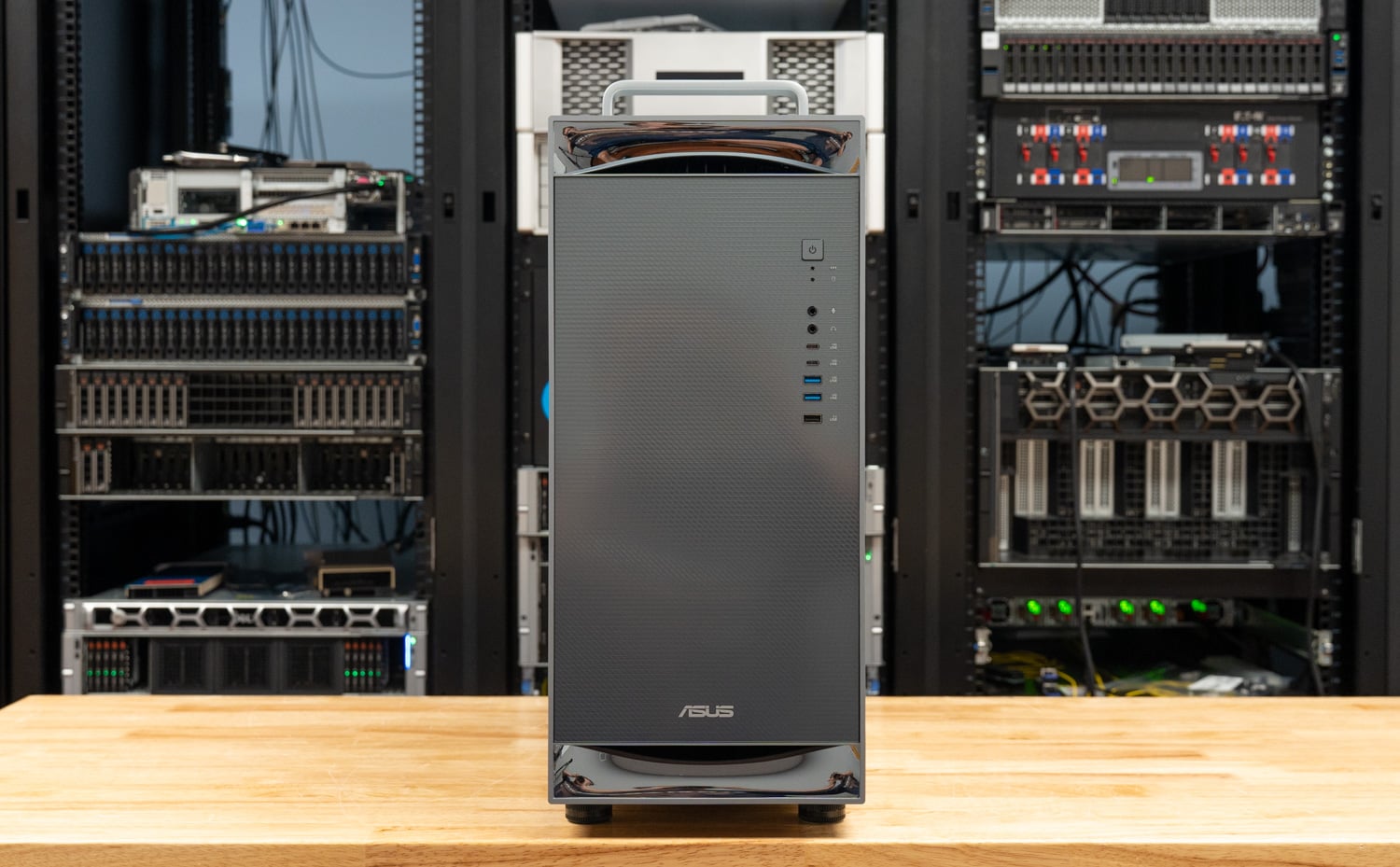 Front of the ASUS ExpertCenter Pro ET900N G3 with its dark mesh panel, top carry handle, power button, front USB Type-A and Type-C ports, audio jacks, and ASUS badge