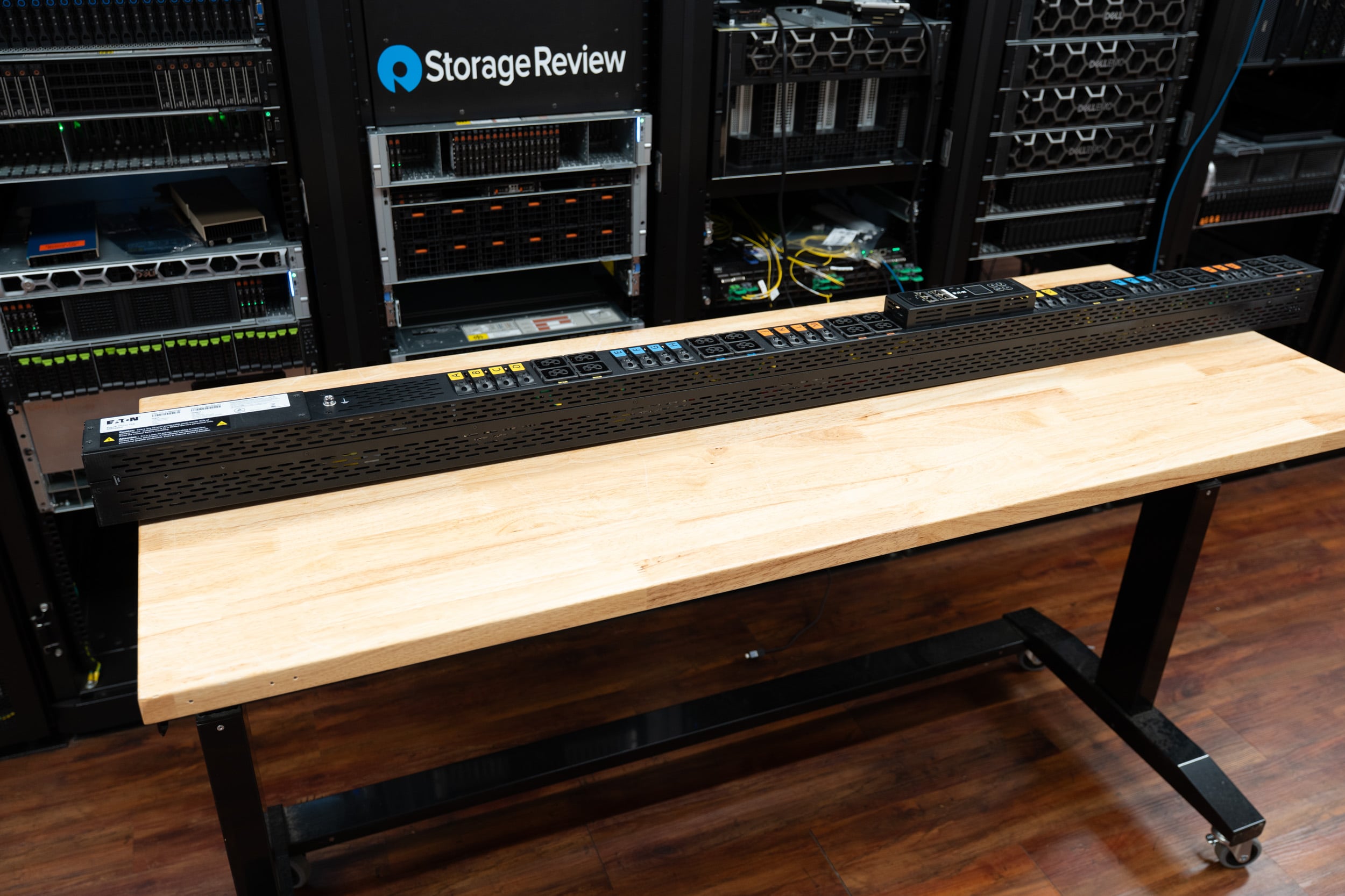 Eaton HDXL Rack PDU angled on the lab bench in front of the StorageReview server racks