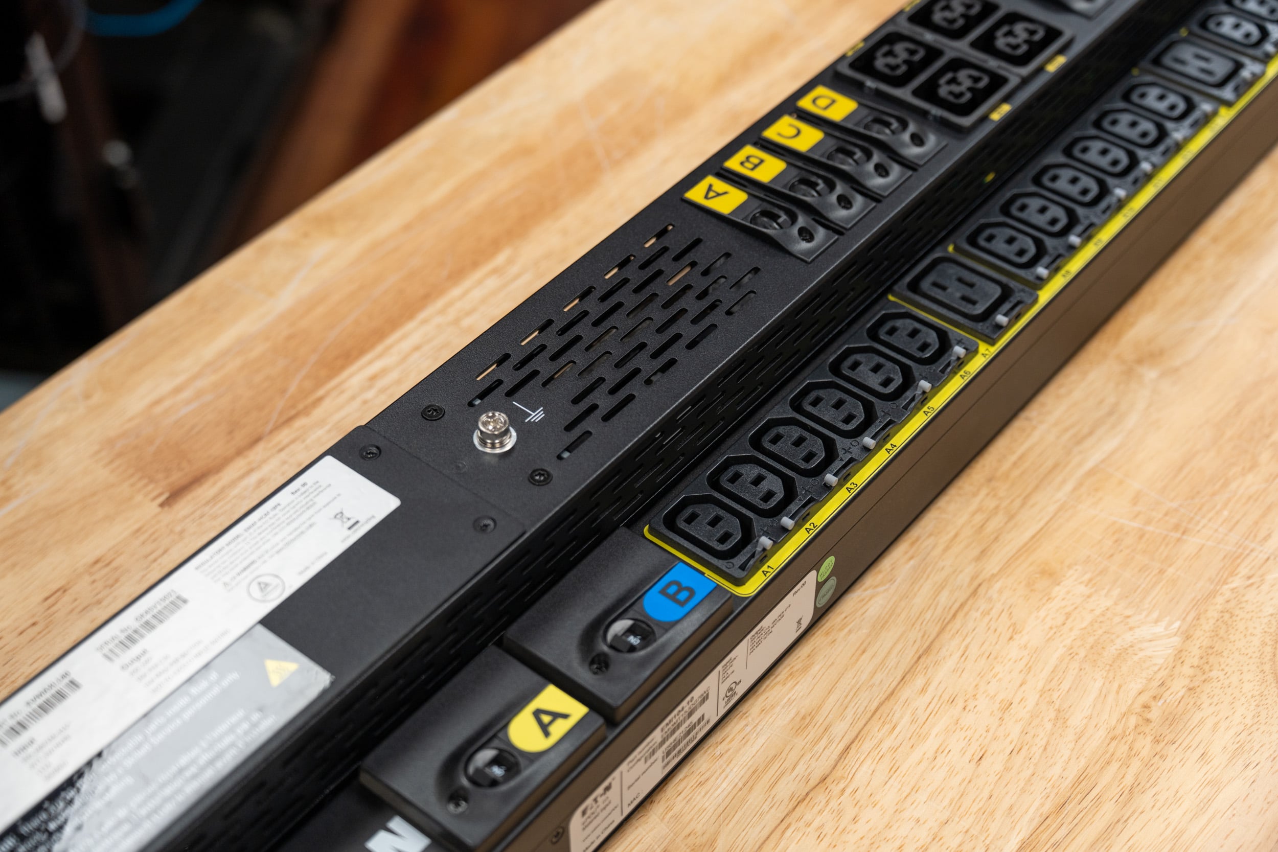 Close-up of Eaton HDXL Rack PDU C39 outlets with lettered breaker labels and the Gigabit Network Module