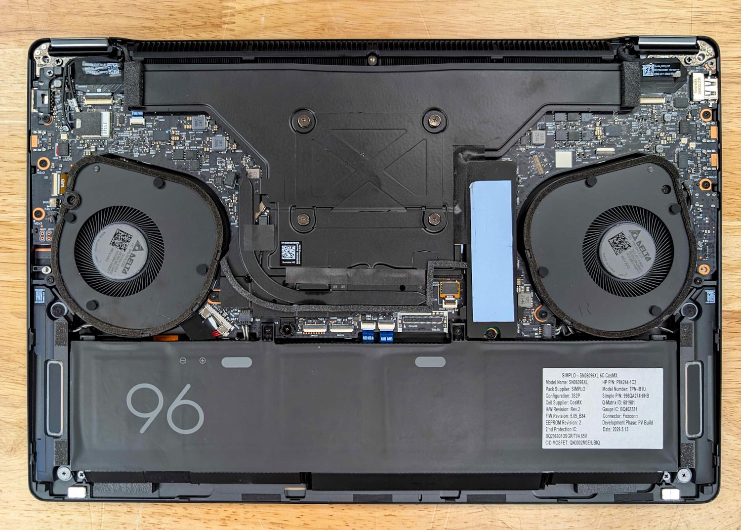 HP ZBook Ultra G3a 16 with the bottom cover removed and the heat spreader installed, showing the plate over the SoC, dual Delta fans, the rear radiator, and the 96Wh battery