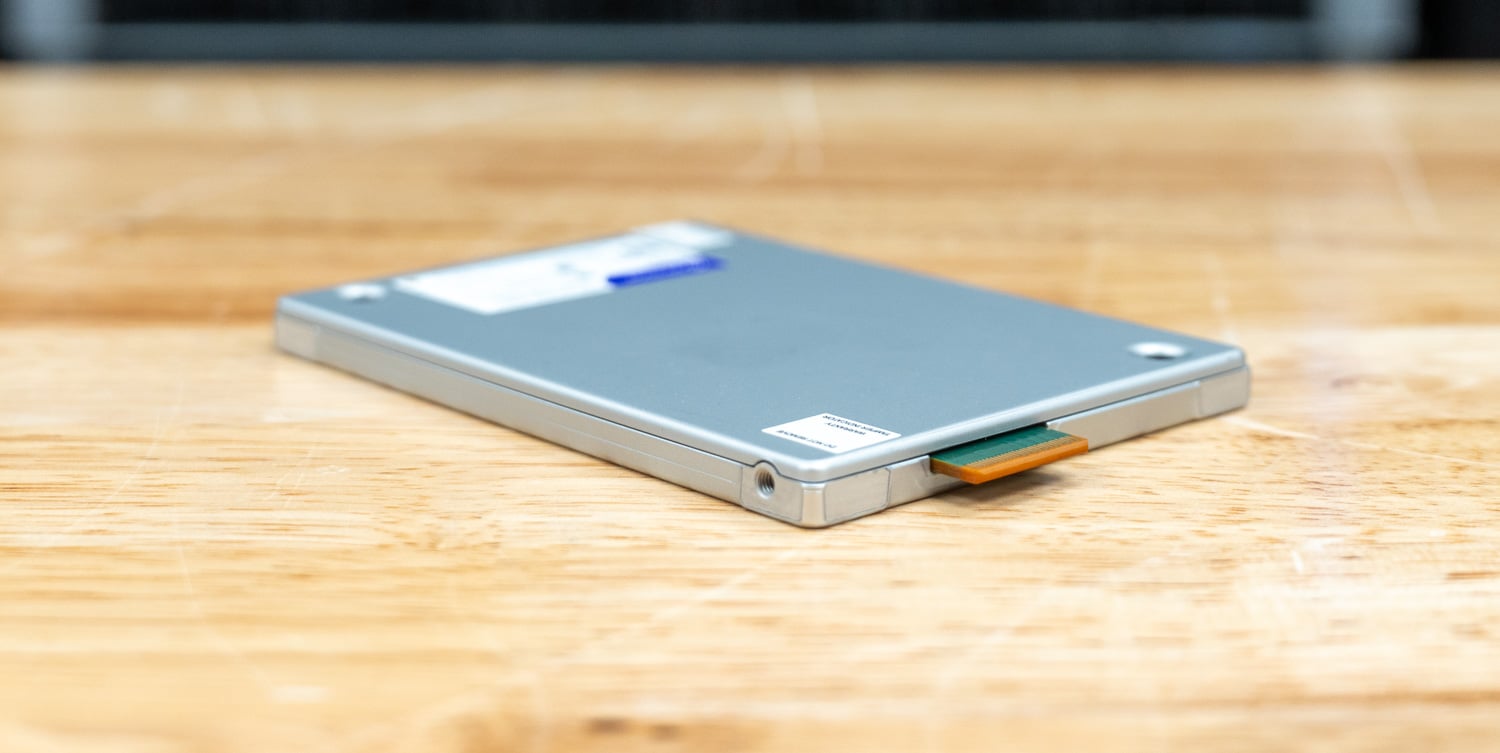 Solidigm D5-P5430 30.72TB E3.S SSD lying flat on the lab bench, showing the 7.5mm case profile and the EDSFF edge connector