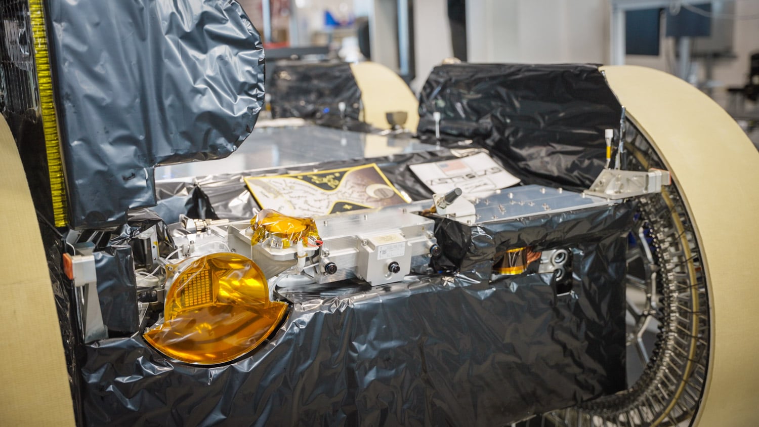 Instruments on the front of the Astrolab FLIP rover, including a headlight, camera array, LiDAR, and image projector, with an American flag patch that flew to the Moon during Apollo