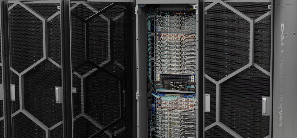 Dell Integrated Rack Scalable Systems cabinets with the center rack open to show a column of PowerEdge M7725 sleds and cabling, the rack-scale hardware behind the Dell AI Factory with NVIDIA